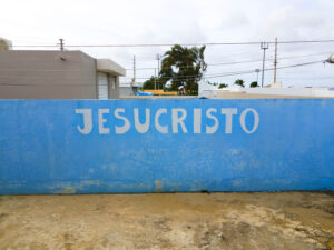Jesus Christ sign in spanish painted on blue cement wall
